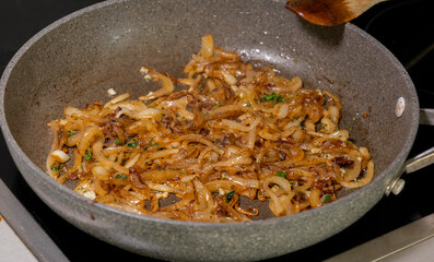 caramelizing onion slices in a pan