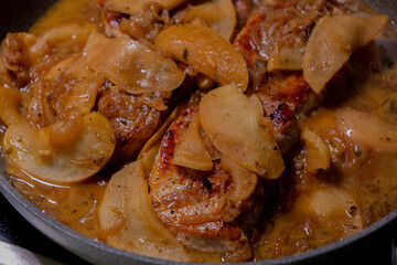 cooking pork chop with apples in a pan
