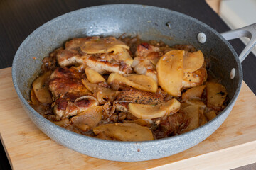 delicious pork chop with onion and apples in pan fall meal