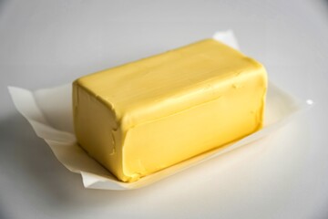 A clean photograph of a rectangular block of fresh, creamy butter