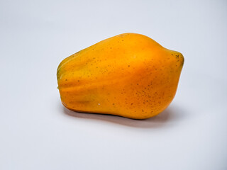 A ripe, whole papaya is set on a pristine white backdrop, radiating warmth and health appeal.