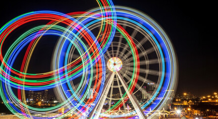 Ferris wheel with colorful light trails in the night sky in dubai