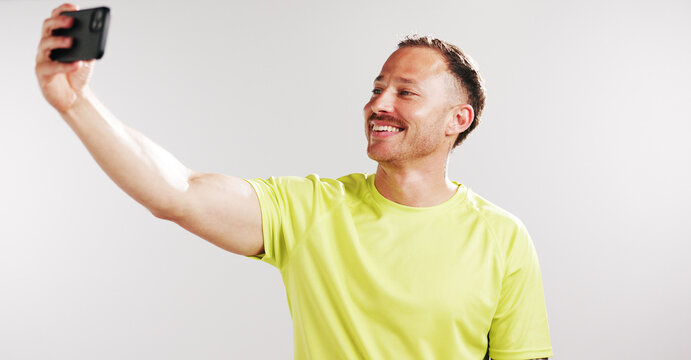Selfie, happy and fitness with man in studio for social media gym membership promotion and memory. Profile picture, personal trainer post and photography with male person on white background - Powered by Adobe
