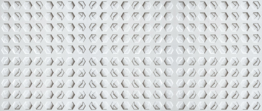 a white, textured surface featuring a grid of hexagonal indentations. Each hexagon has a three-dimensional, geometric design with internal triangular and rectangular patterns