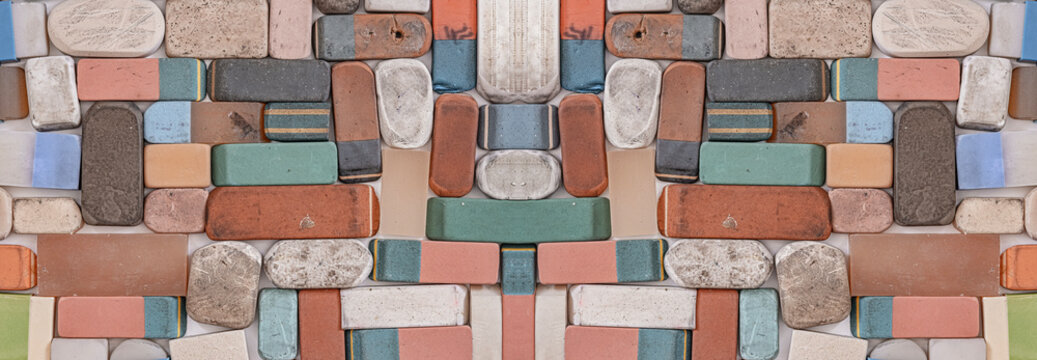 A collection of various used and worn-out erasers, flat lay photograph of a scattered collection of vintage, heavily used, and well-worn rectangular erasers