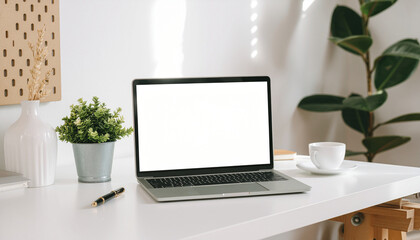 Open laptop with a blank white screen placed on a bright, minimalist home office desk, surrounded by indoor plants, a coffee cup, and sunny light.