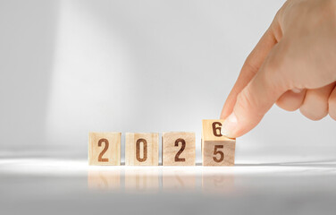 Hand changing wooden cubes from 2025 to 2026 new year concept