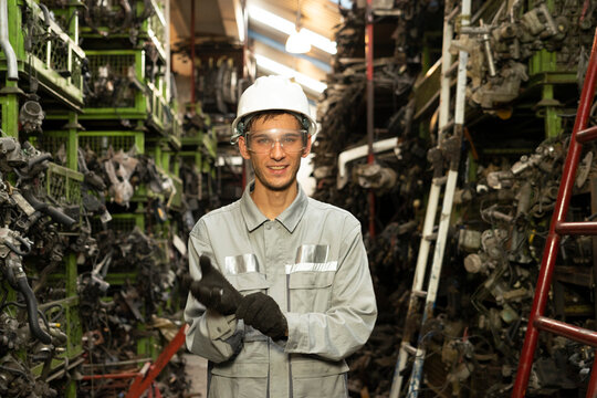 Technician worker working and smile to the camera in garage scrap yard car workshop warehouse.

