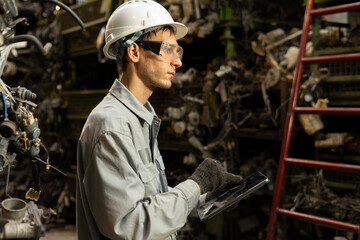 Technician worker working and checking in garage scrap yard car workshop warehouse.
