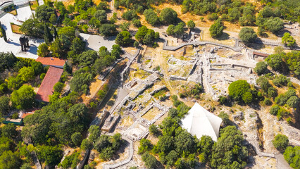 Tevfikiye, Turkey. Stone walls and fortifications of the ancient city of Troy VI, overgrown with grass and shrubs on a summer day. Aerial view
