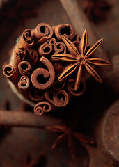 Cinnamon sticks and anise on a rusty background.
