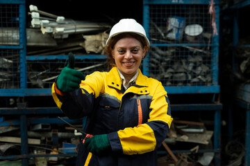 Portrait of technician women worker stand, looking camera happy smiling in garage scrap yard car workshop warehouse.