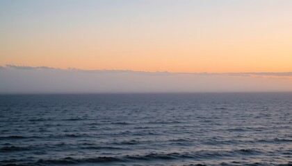 Serene Ocean Sunset Aglow Over Calm Waters with Gentle Waves and Soft Clouds on the Horizon