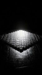 Illuminated diamond pattern floor tile under stark contrast dark lighting