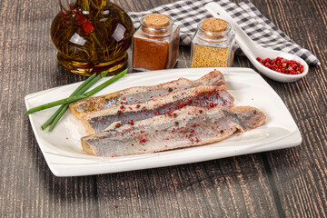 Salted marinated herring fillet with spices