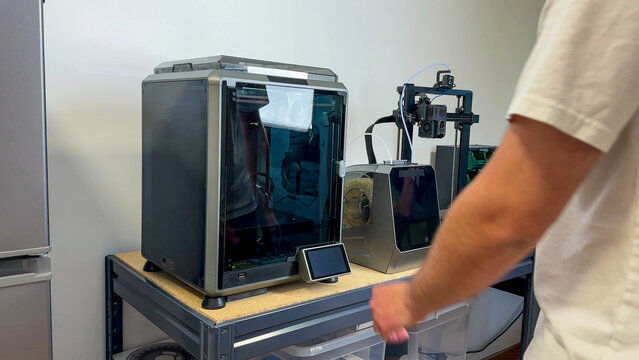 A tech-savvy workspace hums with futuristic 3D printers, embodying International Programmers' Day and geek culture innovation rituals