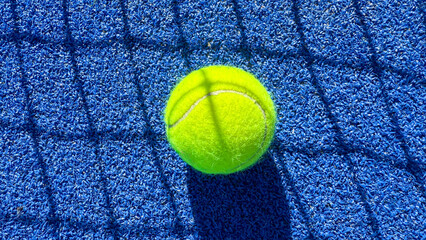 A luminous tennis ball perched on cobalt court, shadow-play whispers, World Tennis Day, athletic precision, sunlit abstraction