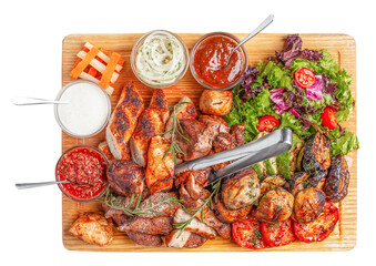 Mixed grilled meat with vegetables, fresh salad and assorted sauces served on wooden board, top view food composition for advertising or restaurant menu design