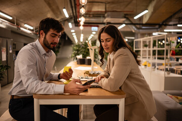 Business colleagues collaborating using smartphone in modern office
