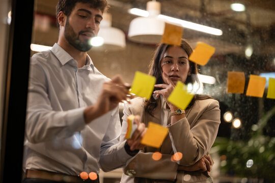 Colleagues brainstorming new ideas using sticky notes