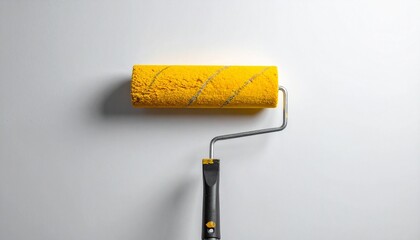 Yellow paint roller with spiral texture and black handle resting against light wall showcasing home improvement and minimal design