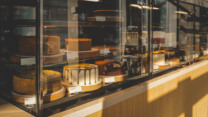 Delicious cakes displayed in a bakery shop window, ready to be purchased