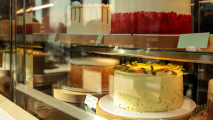 Delicious cakes displayed in a bakery shop window, ready to be purchased