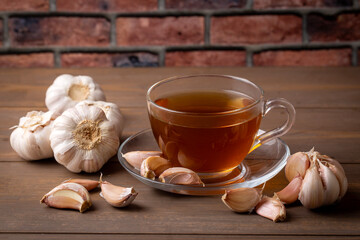 Cup of healthy garlic tea on table