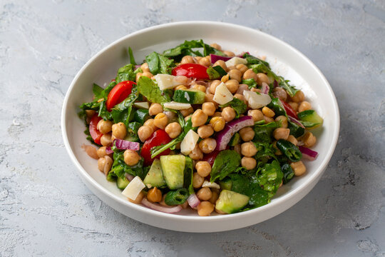 Vegetarian chickpea salad with tomatoes, arugula, parsley, spinach and red onion. Healthy food, diet. Top view