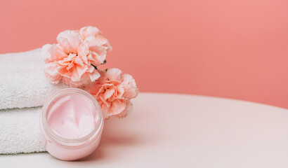 Pink cream jar and carnations with copy space. High quality photo