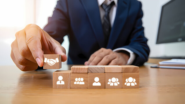 Business man building a team with wooden blocks, symbolizing partnership, collaboration, and human resource management for success - Powered by Adobe