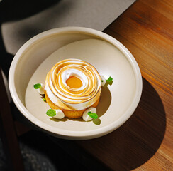 Beautifully crafted dessert with swirls of cream and fresh mint leaves