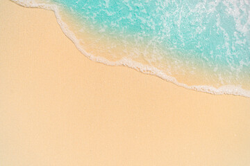 The image shows a close-up of sea foam rolling onto a sandy beach. The clear dividing line between the foam and the sand creates a minimalist and abstract visual effect.