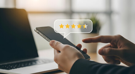 Customer leaving a five star review on a smartphone screen with a laptop in the background