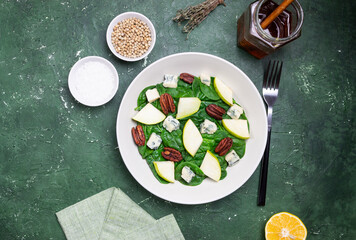Salad with spinach, blue cheese, pear, and nuts. Healthy eating. Vegetarian food.