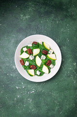 Salad with spinach, blue cheese, pear, and nuts. Healthy eating. Vegetarian food.