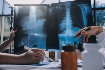 Group of doctors attending seminar in hospital lecture hall with senior physician giving medical...