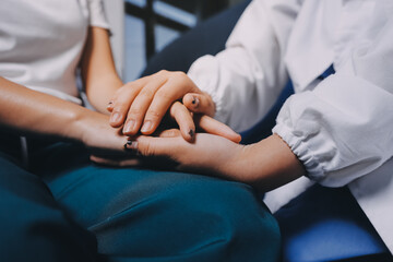 Obraz premium Doctor giving hope. Close up shot of young female physician leaning forward to smiling elderly lady patient holding her hand in palms. Woman caretaker in white coat supporting encouraging old person