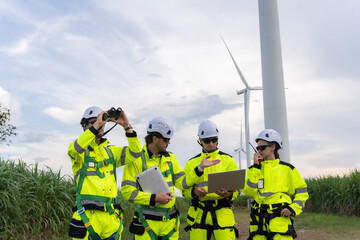 Engineers in safety gear inspecting wind turbines with laptops and binoculars, representing teamwork, clean energy, and sustainable technology industry.