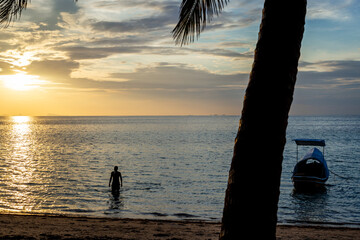 Sunset sea beach with boat on tropical island. Beautiful exotic travel landscape.