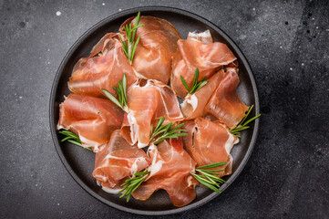 Classic Charcuterie Board with Prosciutto and olives. Dark and rustic food photography for high-end menus or blogs.