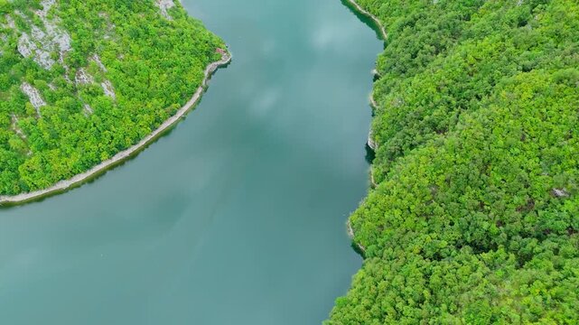 Aerial drone top down view of the Vrbas River in Bosnia and Herzegovina, flowing through green canyons and rocky cliffs