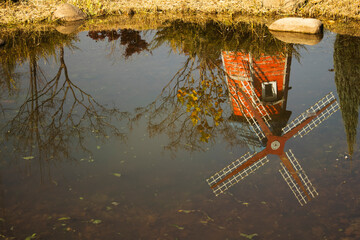 잔잔한 가을 연못에 풍차와 나무의 반영입니다.Reflections of windmills and trees in a calm autumn pond.