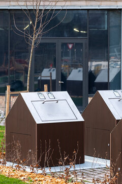 Exterior urban scene showing a row of public waste container units aligned with surrounding architecture, emphasizing a clean design that supports sustainable ecofriendly recycling practices