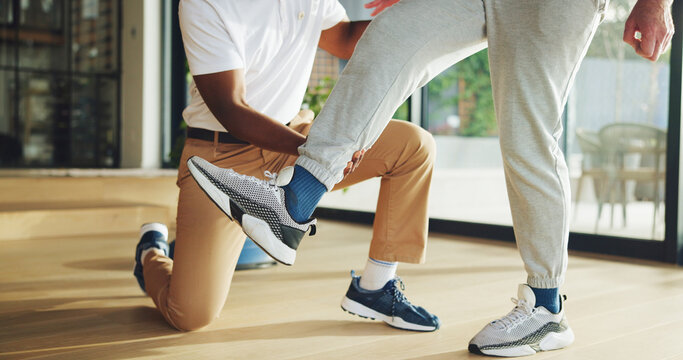 Leg, rehabilitation and stretching with old man and physiotherapist for support, chiropractor and consulting. Help physical therapy and recovery with senior patient in clinic for healthcare