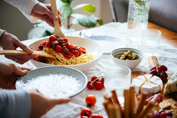 Friends having a pasta dinner with wine at home.
