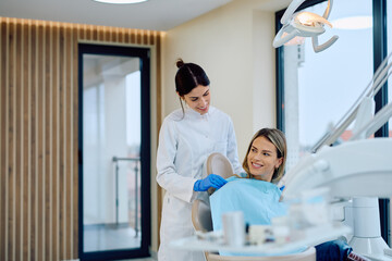 Female dentist helping patient sitting in dental chair for examination, promoting dental healthcare and oral hygiene