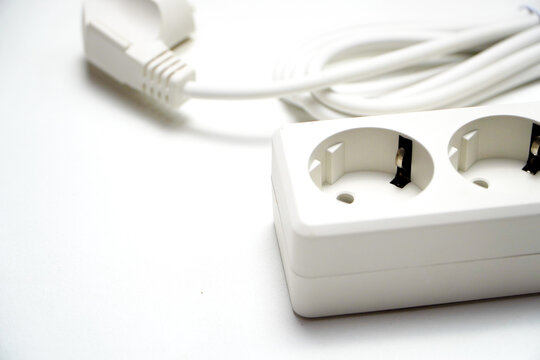 electric plug on white background. Power Strip with Switch: Multi-Socket Outlet for Electrical Appliances. White 4 hole socket ( stop contact) with brown wood background. Close-up of Electrical Cables