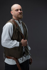 Bald man as wealthy medieval figure in white blouse and vest holding battle axe