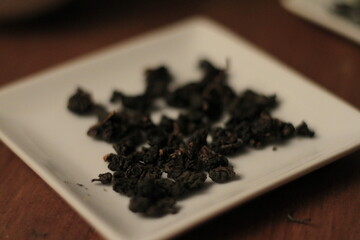 Tea ceremony with white ceramic teapot and cups on wooden table